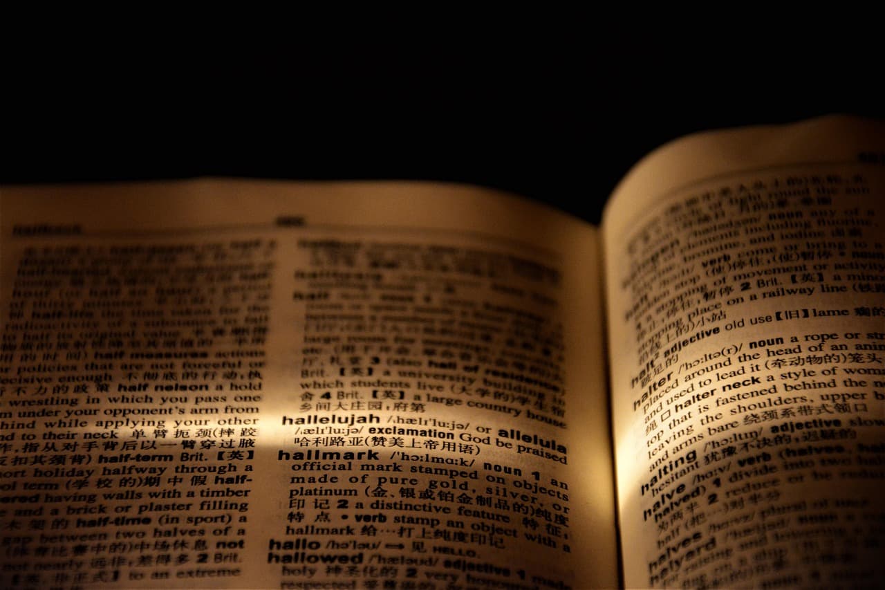 Open dictionary with a magnifying glass over the text