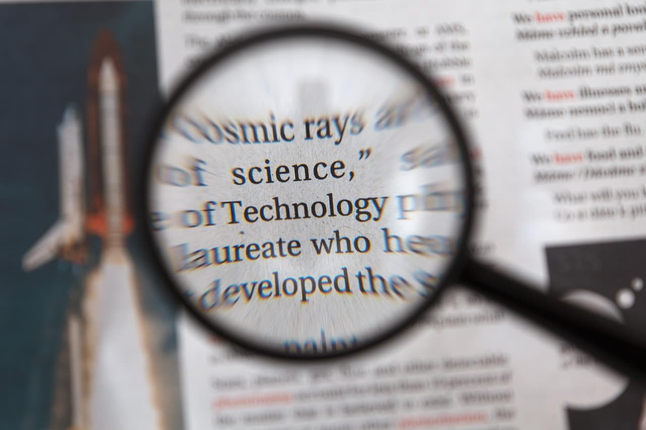 A magnifying glass held over a printed document, examining the text closely