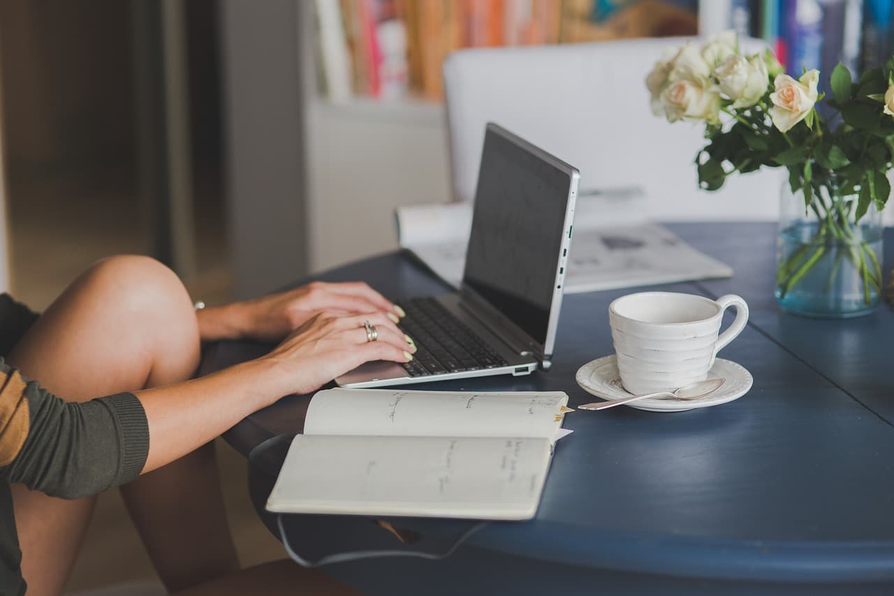 A writer typing at a laptop, drafting and revising a piece of writing