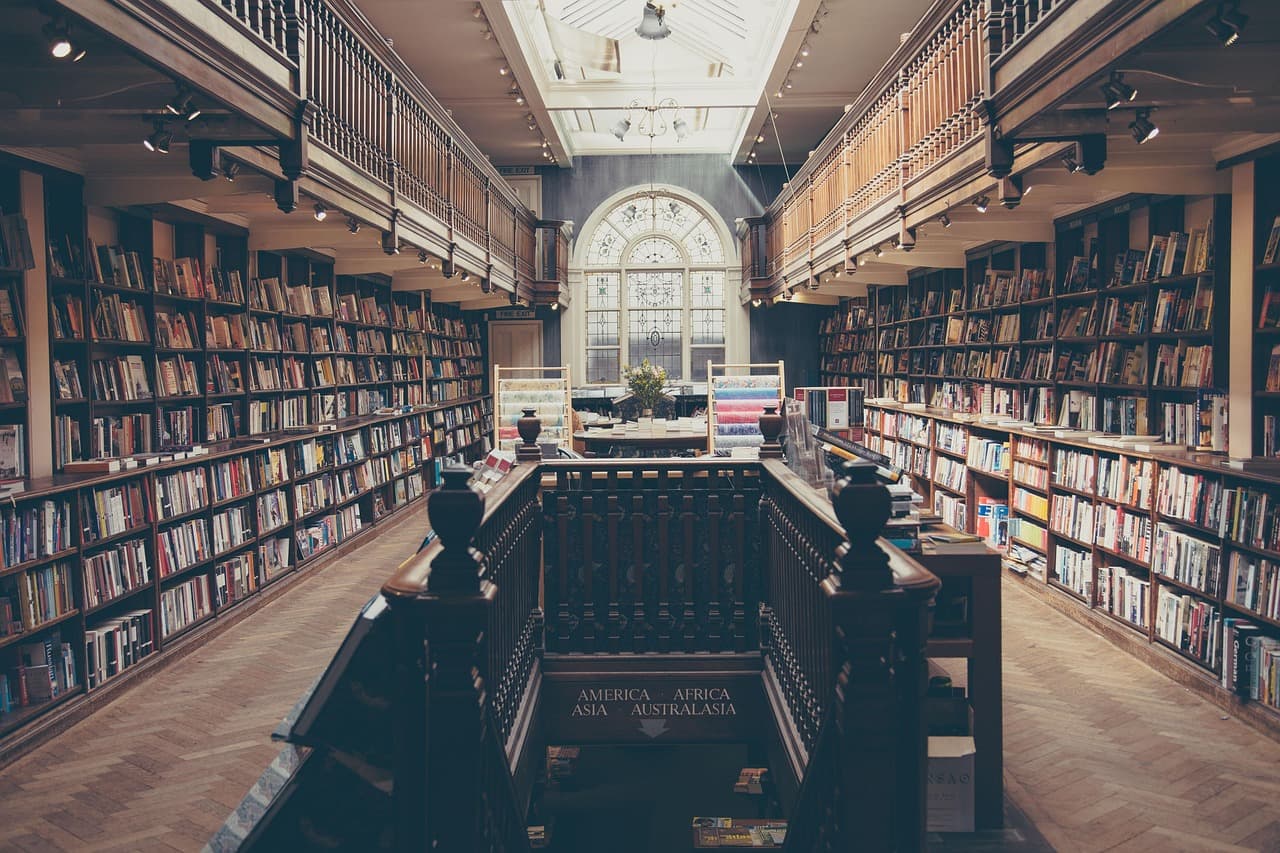 Stack of academic books and research papers on a library table